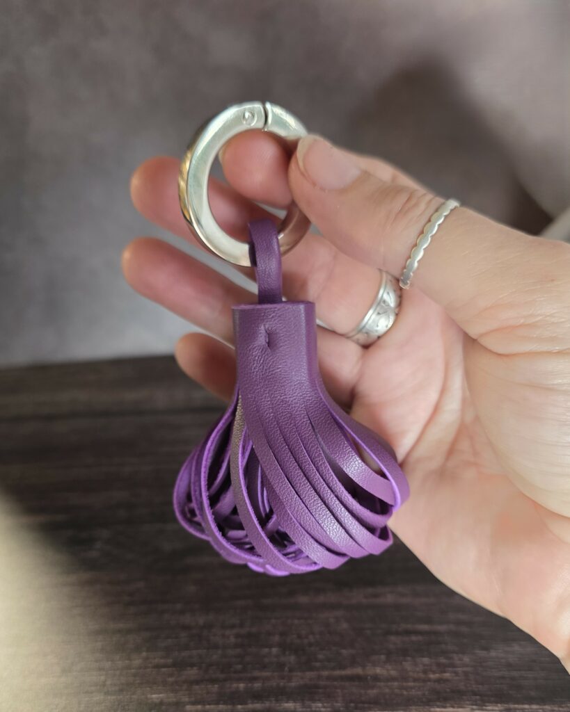 Pompon en cuir avec un anneau mousqueton pour s'en servir comme porte clés