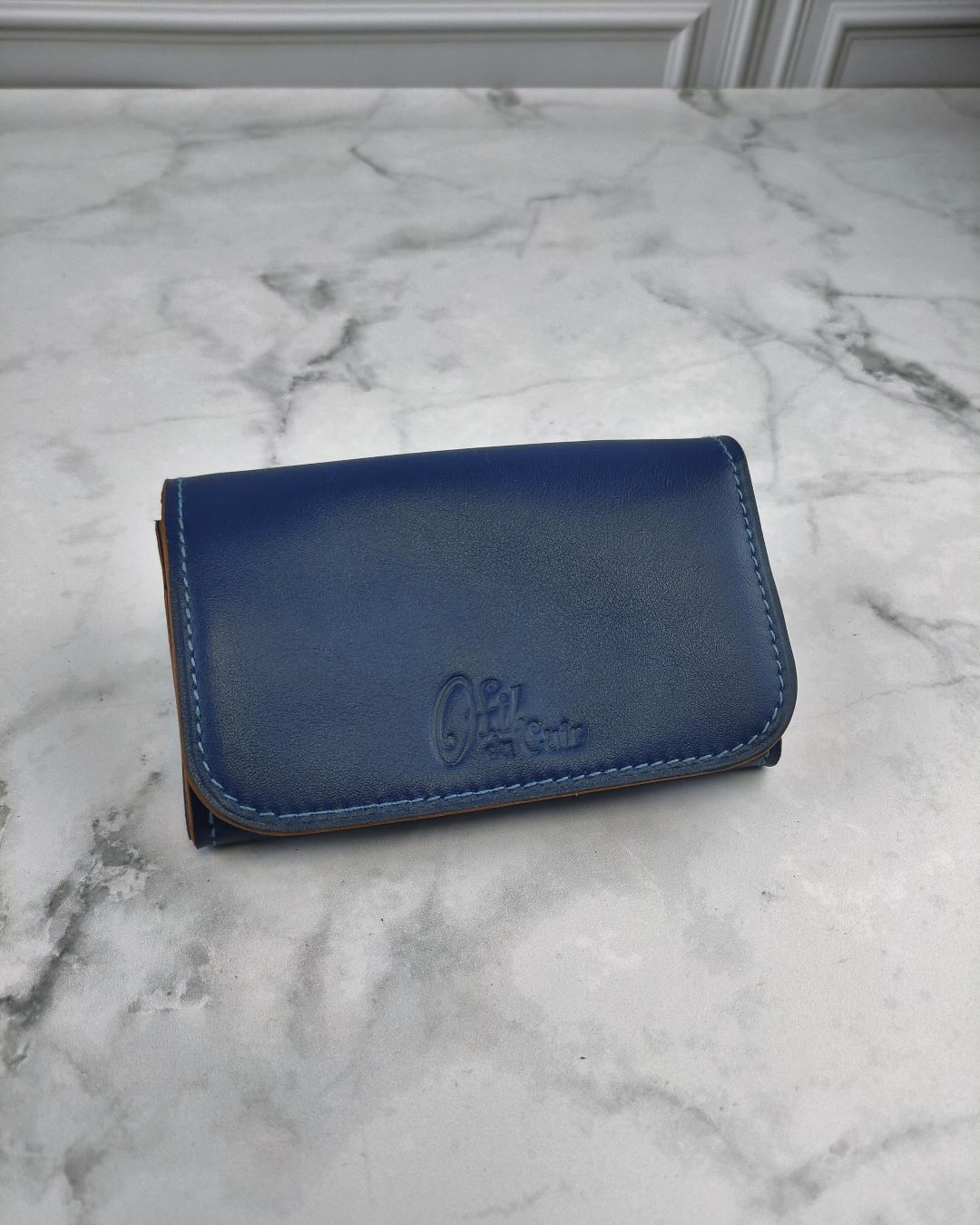 Portefeuille en cuir bleu lisse avec plusieurs poches dont une zippée pour la monnaie