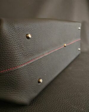 Un sac à main grand format en cuir grainé noir souple avec un fond en cuir rigide