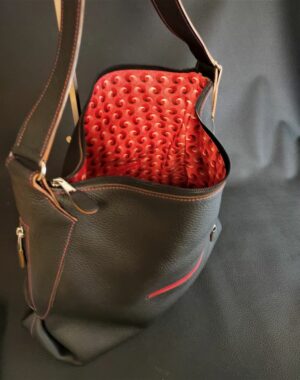 Un sac à main grand format en cuir grainé noir souple et sa doublure en tissu africain rouge