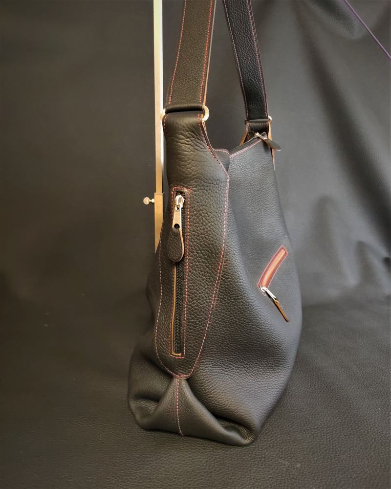 Un sac à main grand format en cuir grainé noir souple et ses 3 poches extérieures