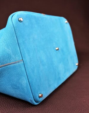 Sac à main en cuir nubuck bleu avec cinq clous de fond pour le protéger