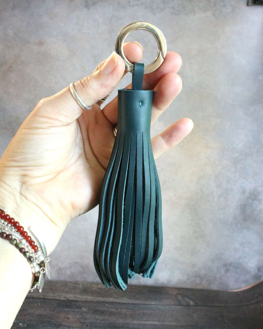 Pompon-en-cuir-vert Pompon en cuir vert avec un anneau mousqueton pour l'accrocher aux clef s ou au sac à main