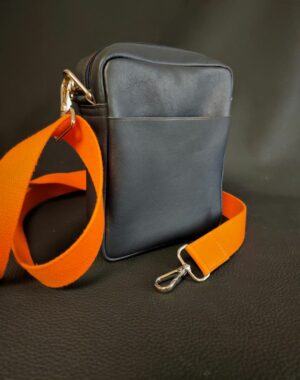 Un sac pochette homme en cuir bleu souple bandoulière sangle orange