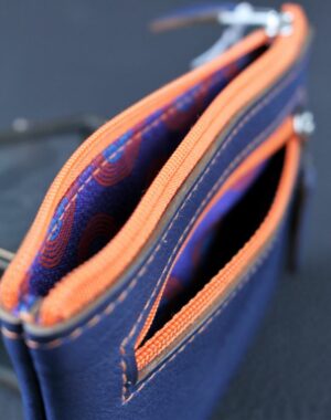Porte monnaie en cuir bleu avec deux poches doublées en tissus africain et zip orange