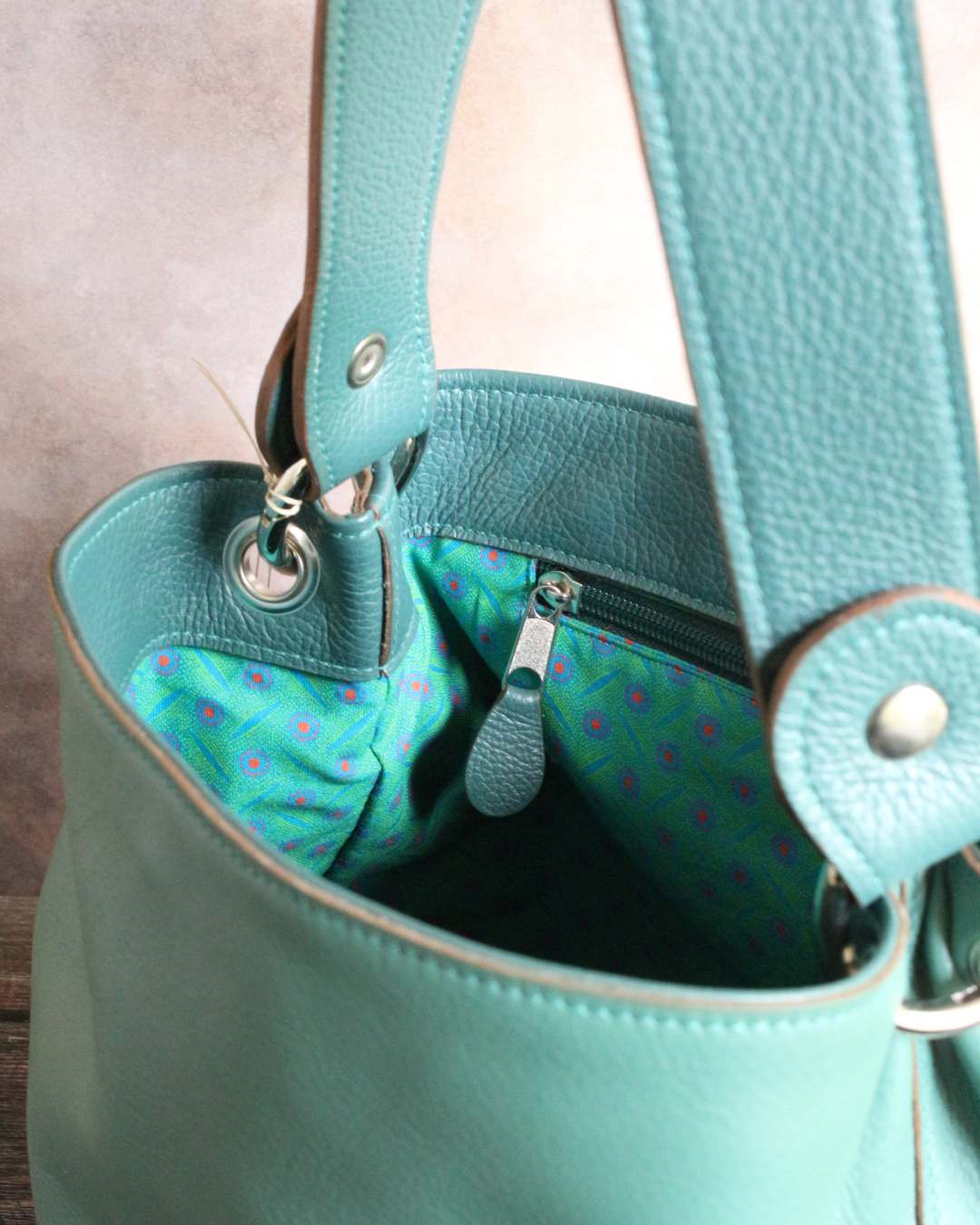 Sac-a-main-seau-en-cuir-vert-artisanal Sac à main seau en cuir vert avec l'anse amovible et l'intérieur en tissu africain et accessoires métalliques nickelé